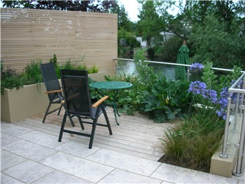 Decked seating area and a raised bed for herbs